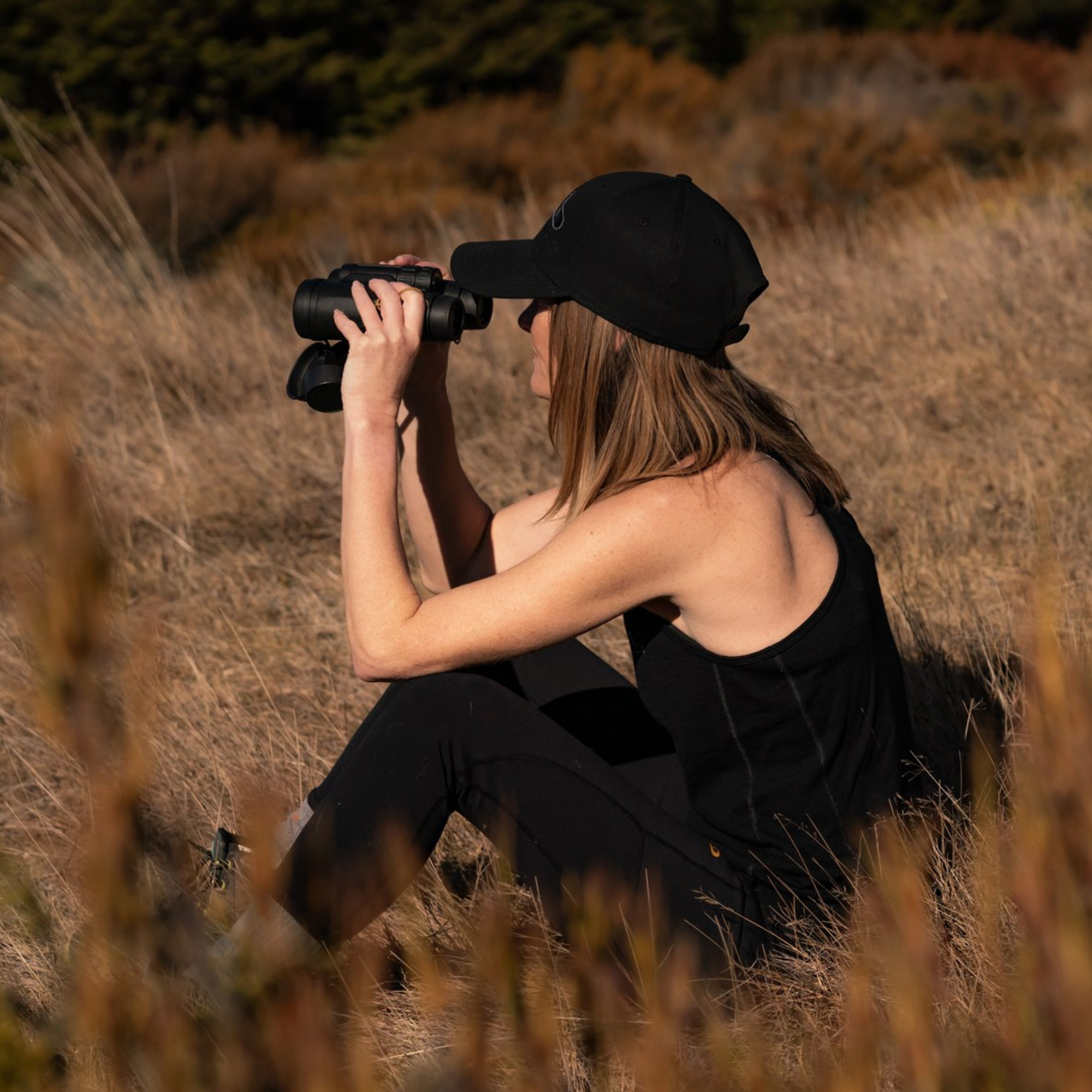 Main Divide Apparel women’s outdoor clothing in use - glassing terrain on NZ backcountry trip
