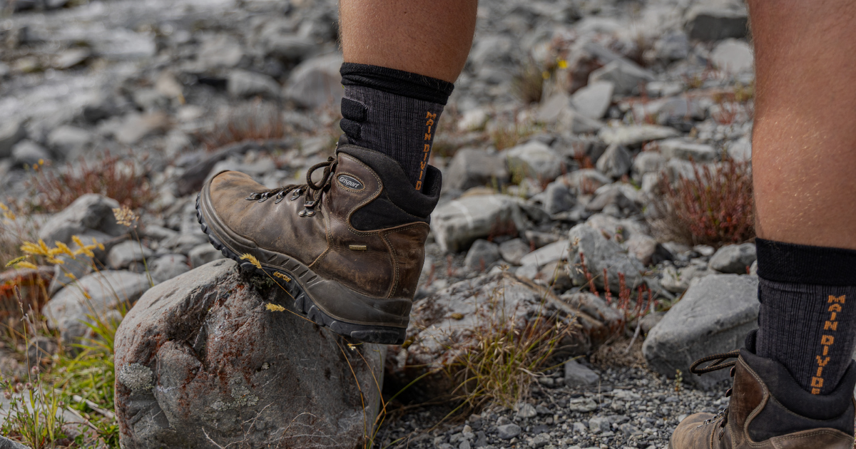 Main Divide merino socks worn with rugged hiking boots on rocky alpine terrain, New Zealand