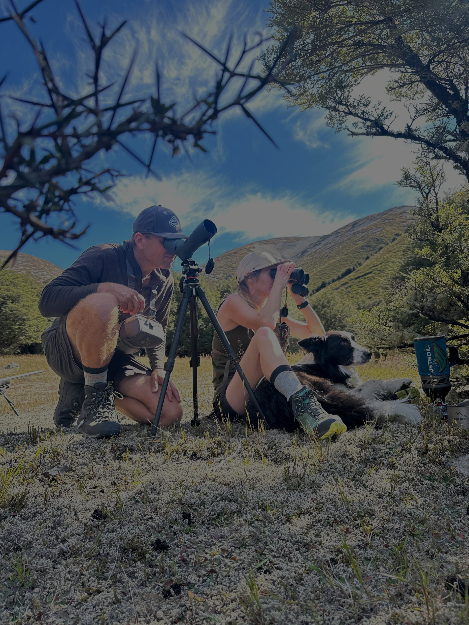 Hunters scouting with binoculars and dog in NZ alpine valley | Main Divide Apparel outdoor gear